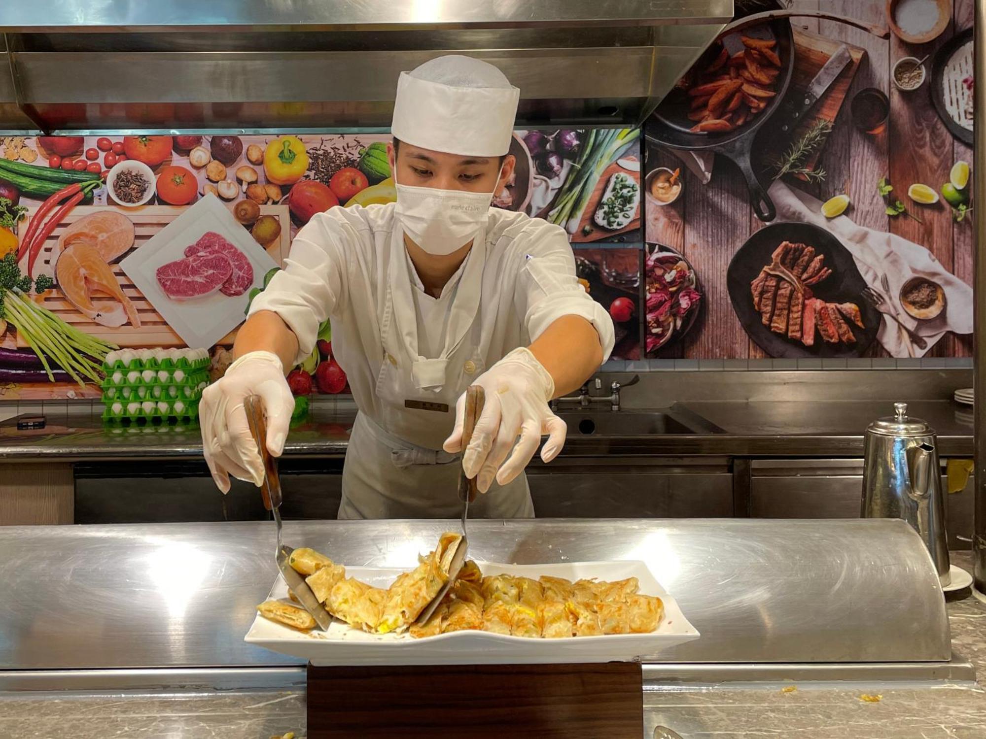 Howard Beach Resort Кэньдин Экстерьер фото A cook wearing a hair net and a face mask